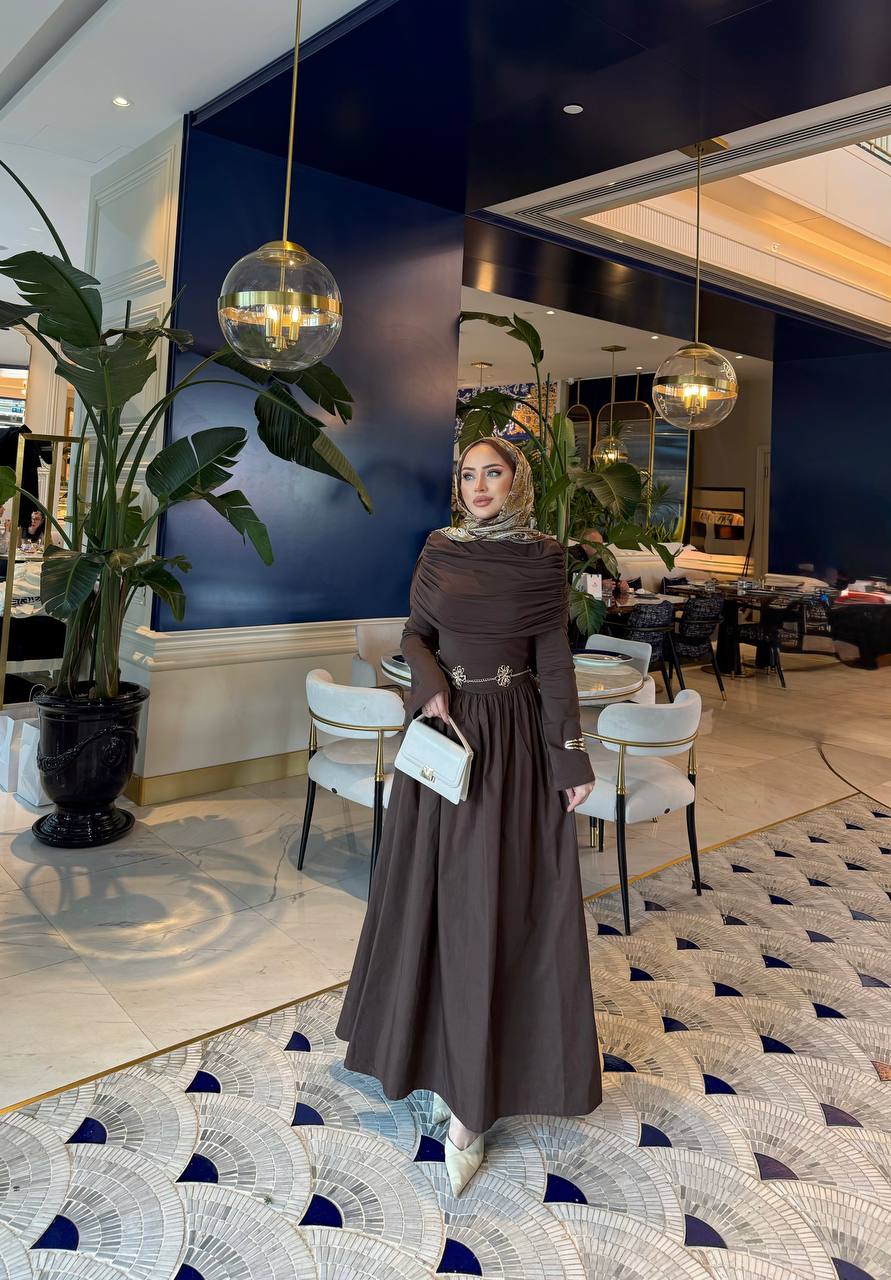 Elegante bruine maxi-jurk met drape details aan de voorzijde, lange mouwen en een flatterende pasvorm – ideaal voor een stijlvolle, bescheiden look