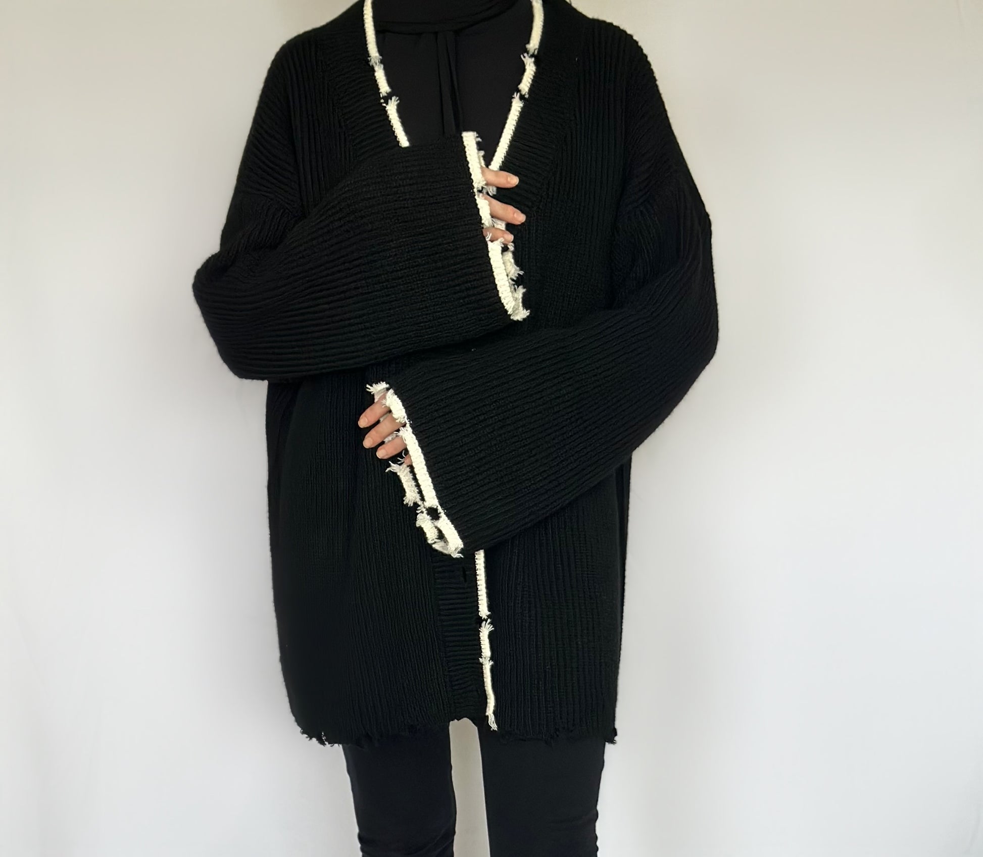 Heerlijk warme oversized zwarte vest van ByLiya, komt tot de dijen met witte randen en scheurdetails voor een trendy uitstraling.
