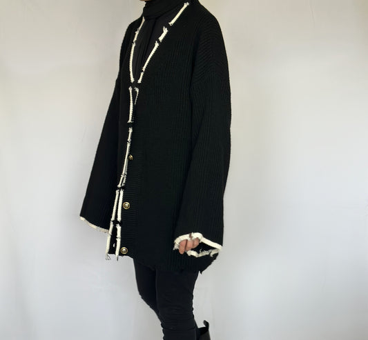 Heerlijk warme oversized zwarte vest van ByLiya, komt tot de dijen met witte randen en scheurdetails voor een trendy uitstraling.