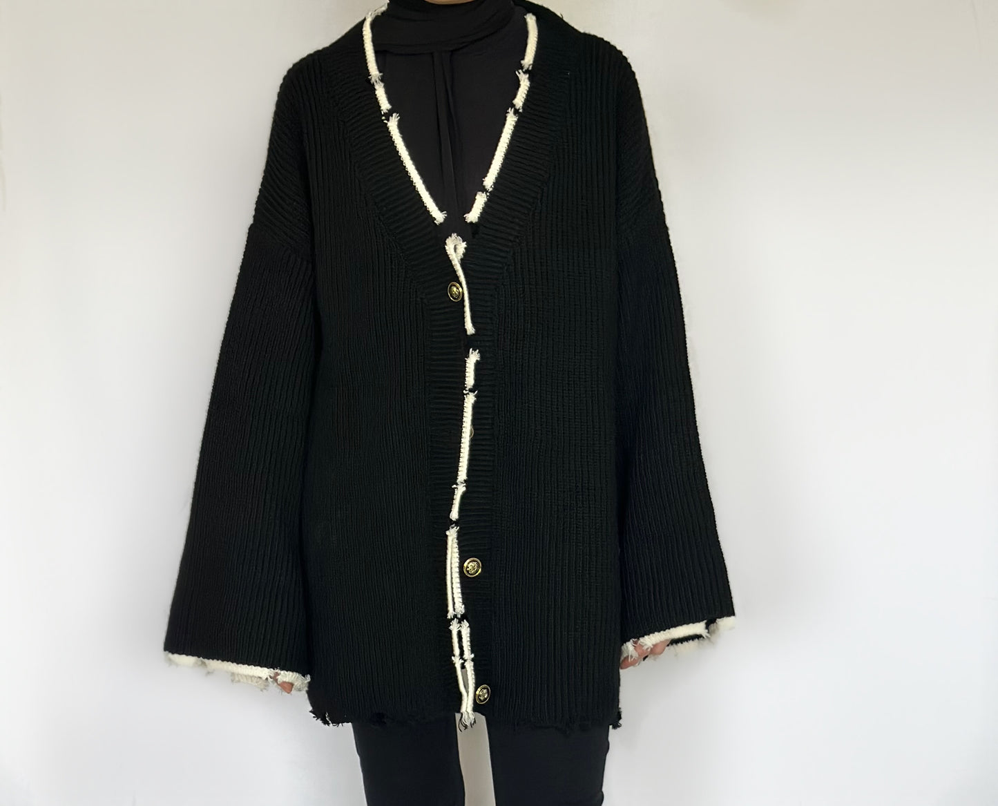 Heerlijk warme oversized zwarte vest van ByLiya, komt tot de dijen met witte randen en scheurdetails voor een trendy uitstraling.