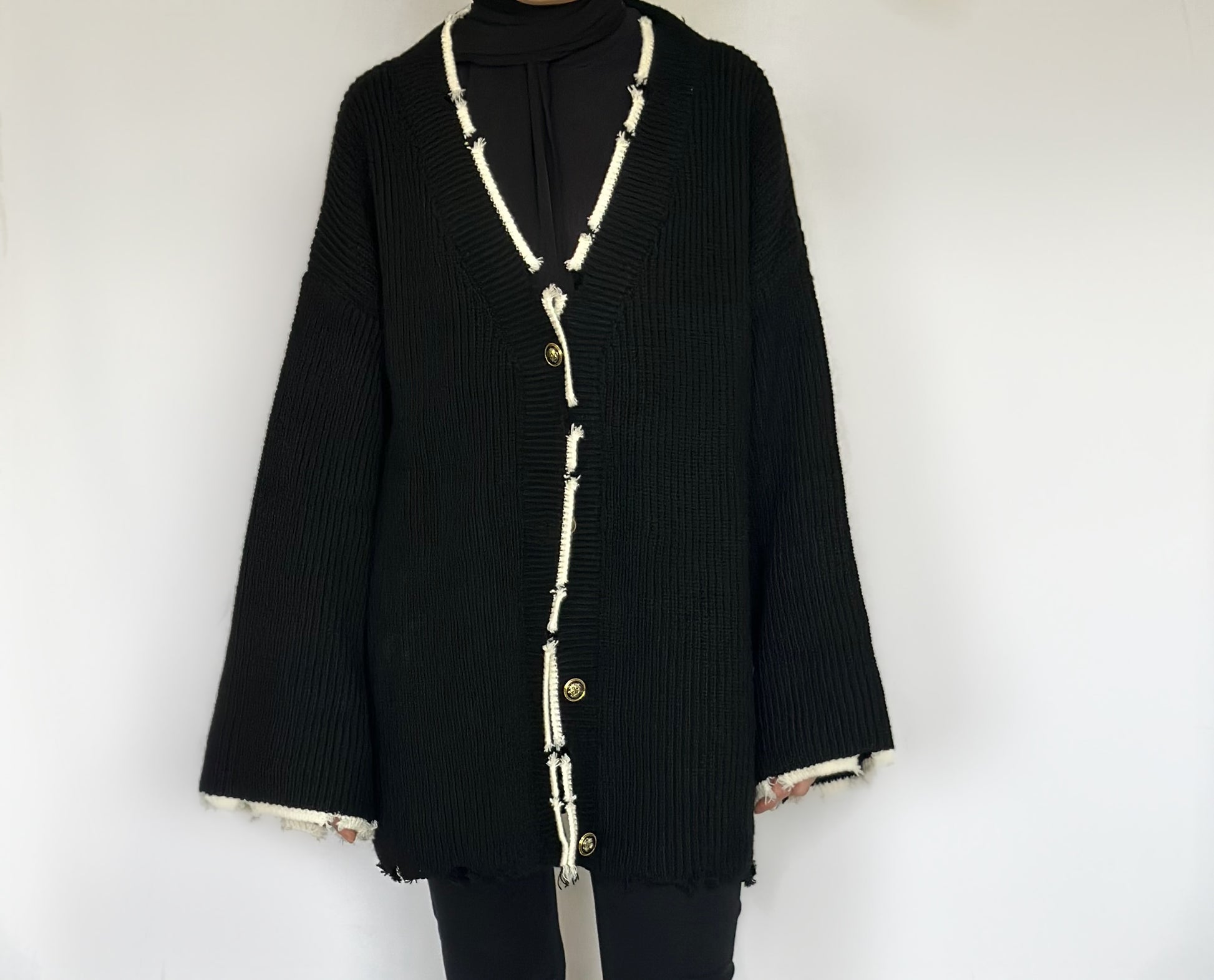 Heerlijk warme oversized zwarte vest van ByLiya, komt tot de dijen met witte randen en scheurdetails voor een trendy uitstraling.