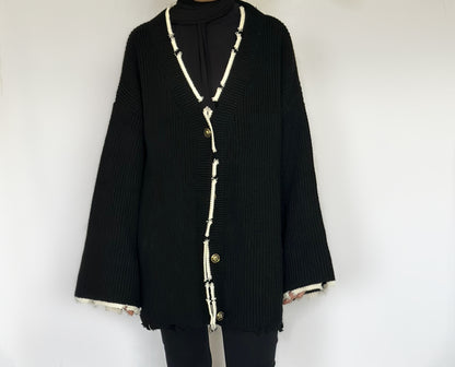 Heerlijk warme oversized zwarte vest van ByLiya, komt tot de dijen met witte randen en scheurdetails voor een trendy uitstraling.