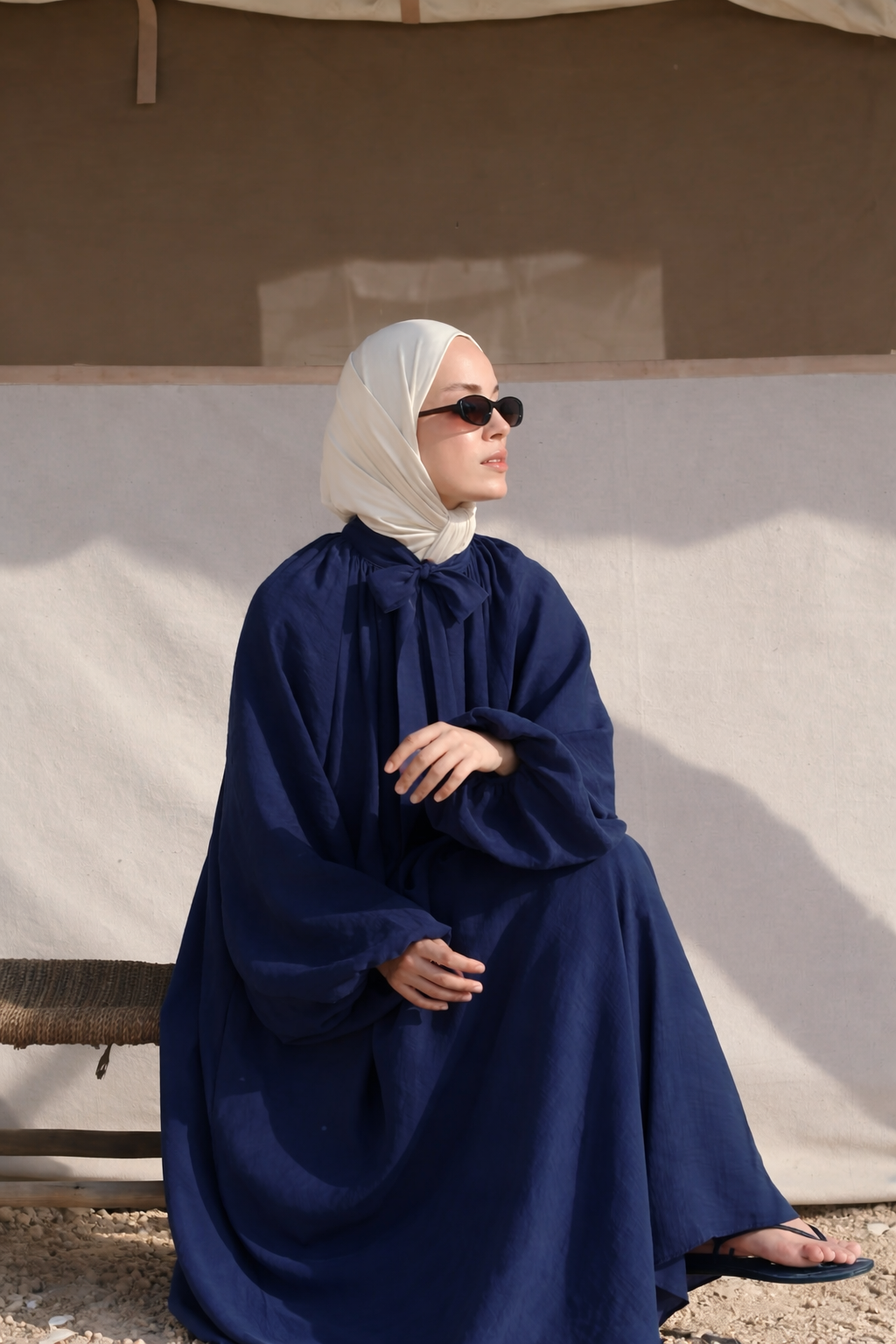 Maira maxi-jurk voor dames in marineblauw met verstelbaar taillelint, lange pofmouwen, hoge halslijn en soepelvallende stof, elegant modest fashion model.