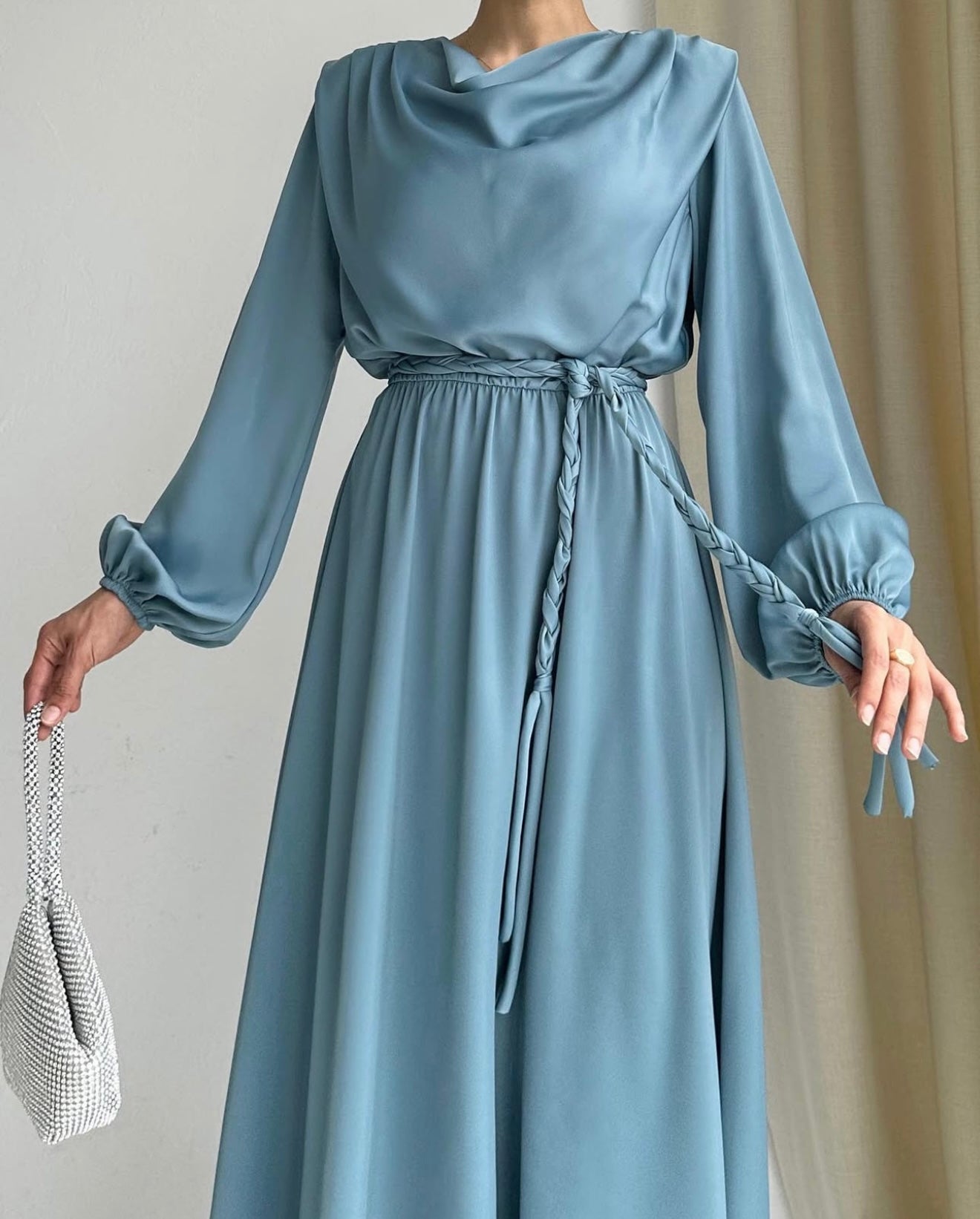 Model draagt de Liyana Dress in mint blauw – losvallende maxi jurk met rechte snit en strikceintuur in de taille