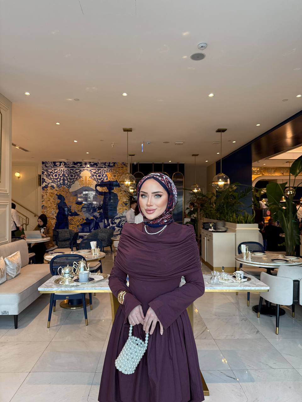Elegante bordeaux maxi-jurk met drape details aan de voorzijde, lange mouwen en een flatterende pasvorm – ideaal voor een stijlvolle, bescheiden look